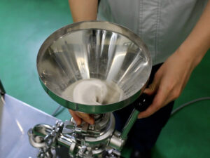 Powder is broken up while being drawn in