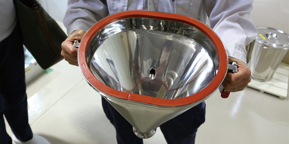 Hopper-shaped connection component attached to the mill